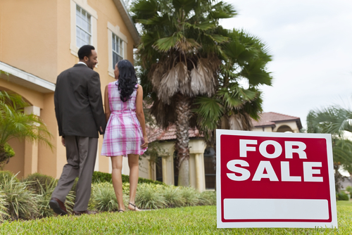 Approved Mortgage - a couple outside of a house for sale