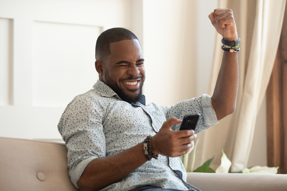 Approved Mortgage - a man excited about something on his phone